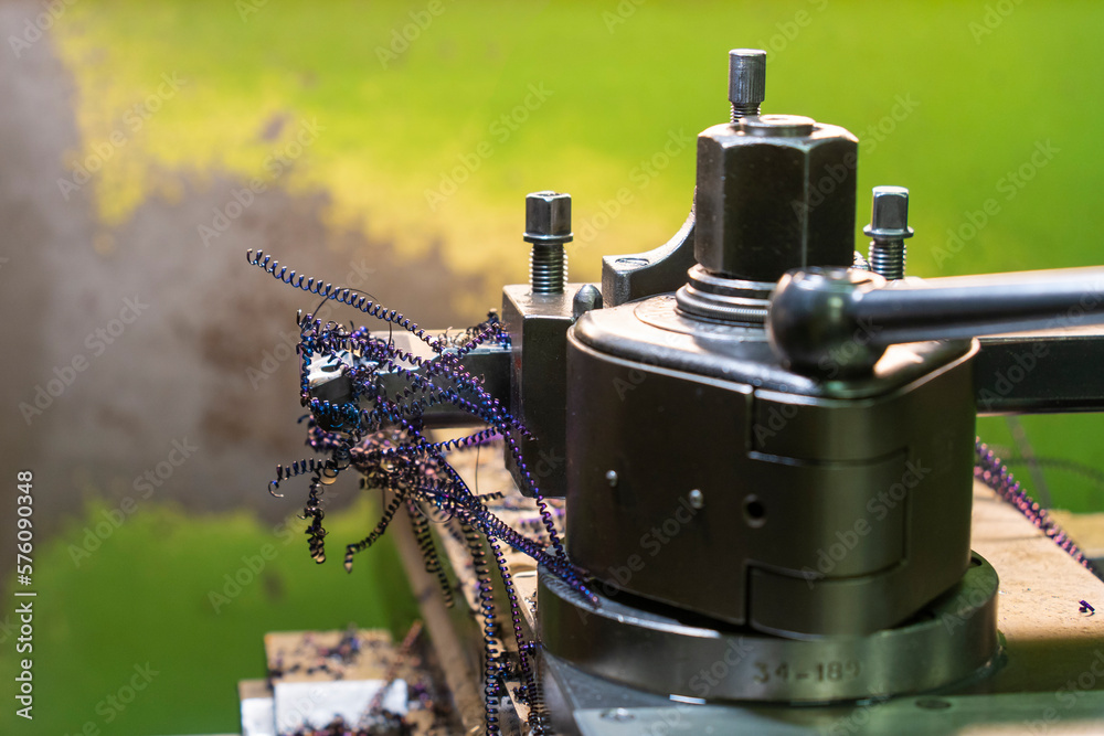 Purple metal shavings on a lathe against a green background