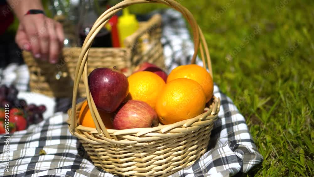 Hombre agarrando una naranja en la canasta de un picnic