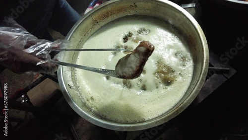 Boiling water with chicken in a pot on a hot stove. Boiling water from heating soup