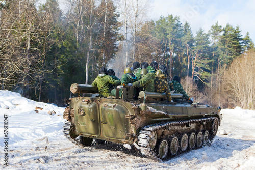 russian military tank with soldiers in ukraine in winter goes on the attack under fire