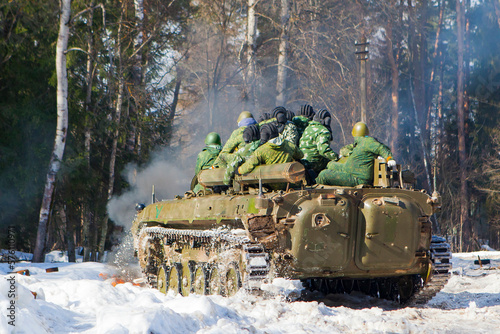 russian military tank with soldiers in ukraine in winter goes on the attack under fire