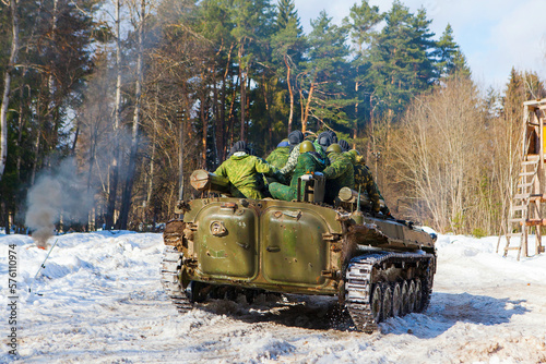 russian military tank with soldiers in ukraine in winter goes on the attack under fire