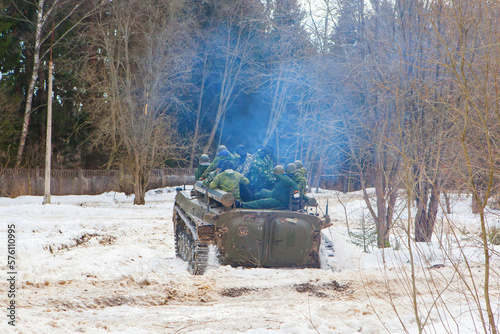 russian military tank with soldiers in ukraine in winter goes on the attack under fire