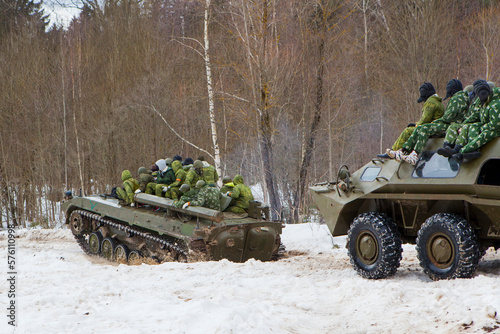 russian military tank with soldiers in ukraine in winter goes on the attack under fire