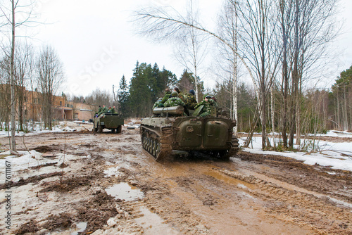 russian military tank with soldiers in ukraine in winter goes on the attack under fire