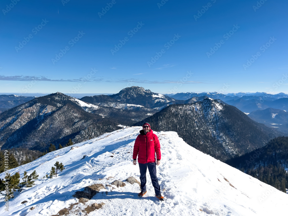 Hiker at the Jochberg peak with the Walchensee lake at the background landscape