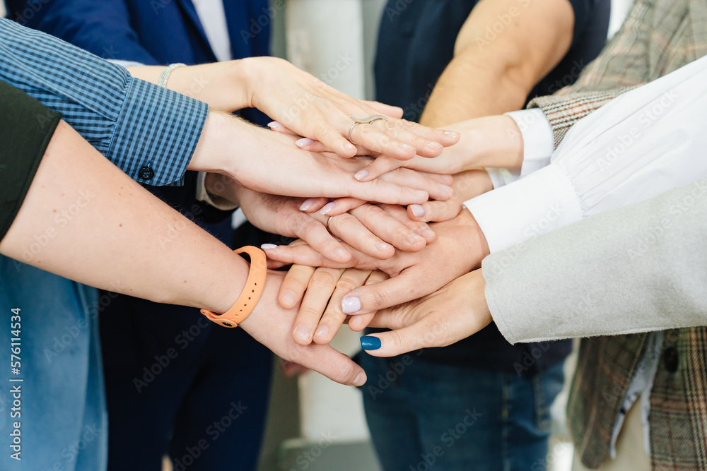 women's and men's hands folded together. the concept of teamwork and support. women's and men's hands folded together. the concept of teamwork and support.