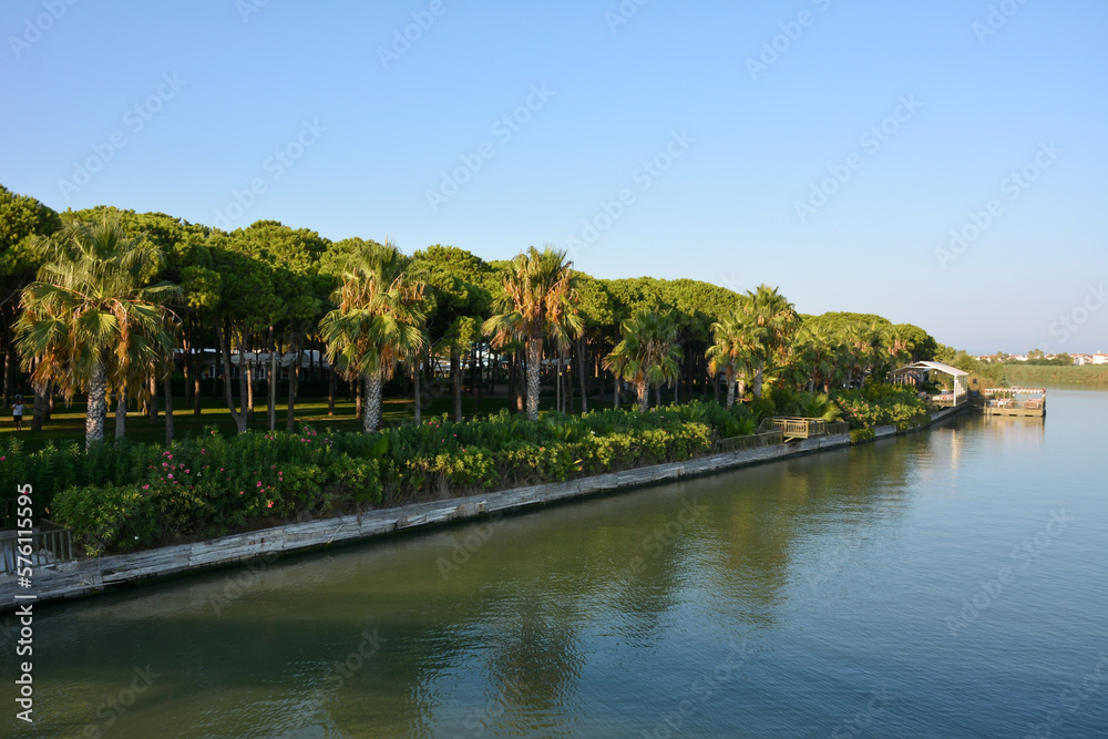 Beautiful embankment near the river with palm trees, a park and gazebos