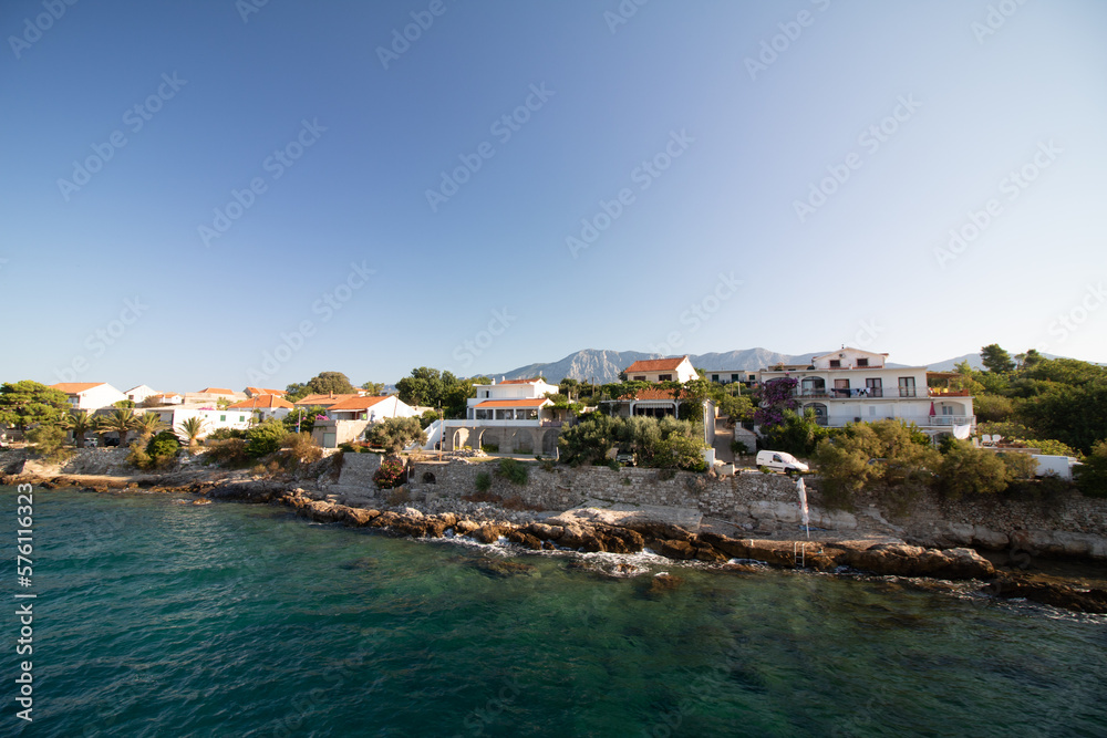 sea ​​view of the coast of the Croatian island of Hvar with typical buildings during summer with blue sky