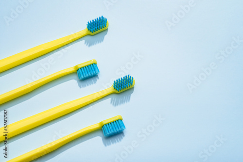 Modern yellow kids toothbrushes on a blue background. Copy space for your text 