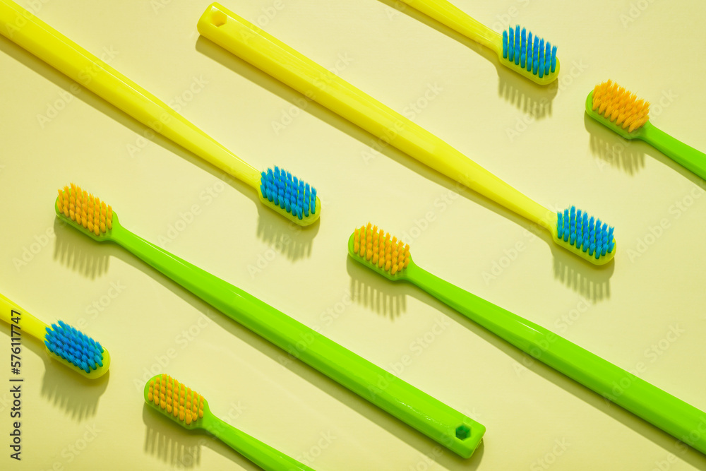 Different colors family toothbrushes, green and yellow on a yellow background. Different colors family toothbrushes, green and yellow on a yellow background.
