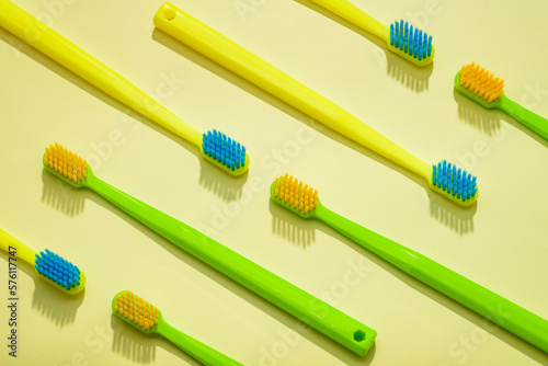 Different colors family toothbrushes  green and yellow on a yellow background.