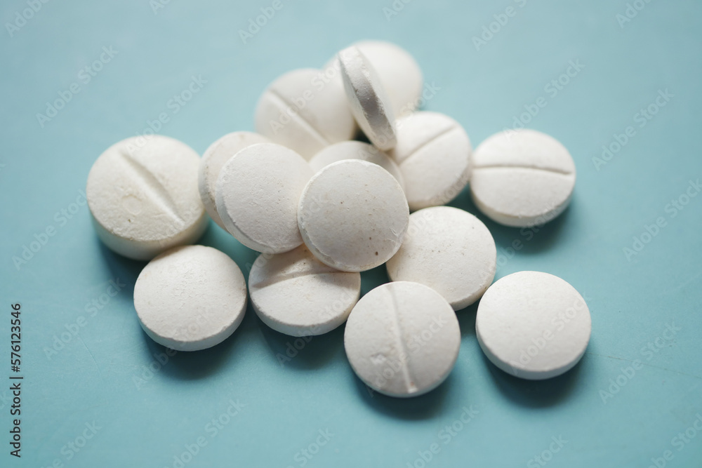 white color medical pills spilling on pink white color medical pills spilling on pink