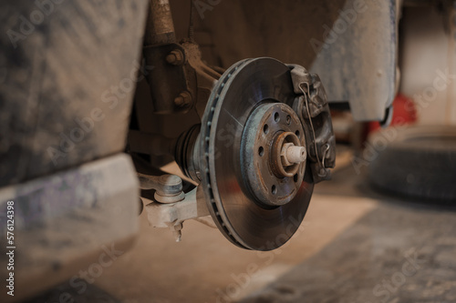 Car brake part in the garage, car brake disc without wheels. Car suspension. Current car repair