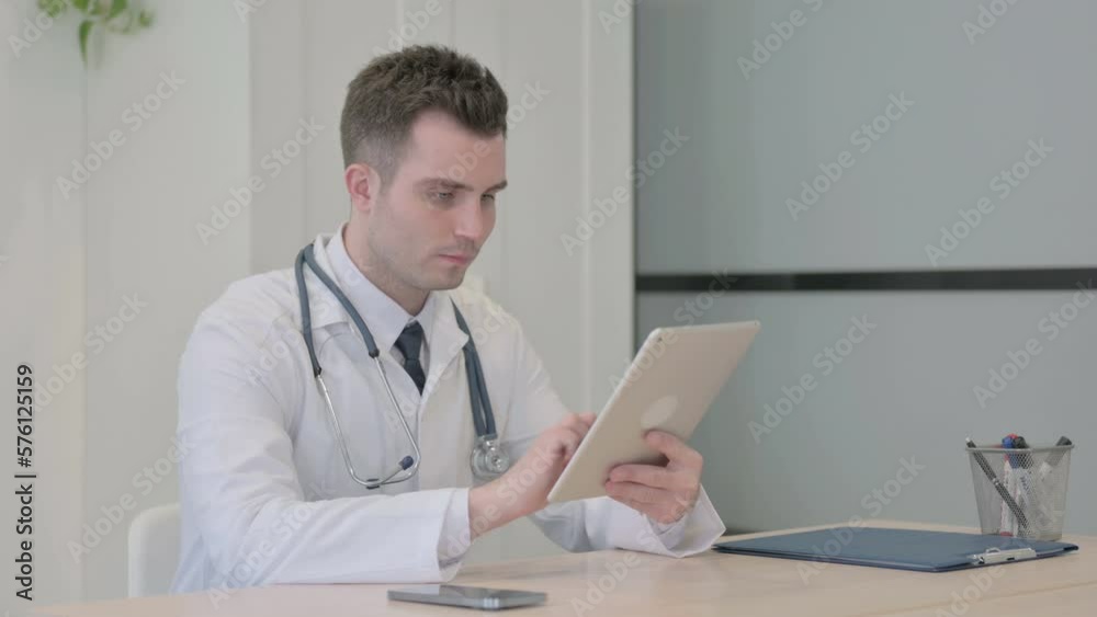 Young Doctor Browsing Tablet in Clinic Young Doctor Browsing Tablet in Clinic