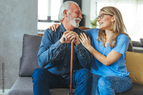 Cropped shot of an attractive young nurse sitting and comforting a senior patient in the living room of his home. Doctor or nurse caregiver with senior man at home or nursing home