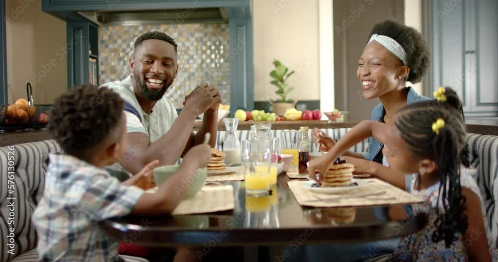 Happy african american family having breakfast, in slow motion Happy african american family having breakfast, in slow motion