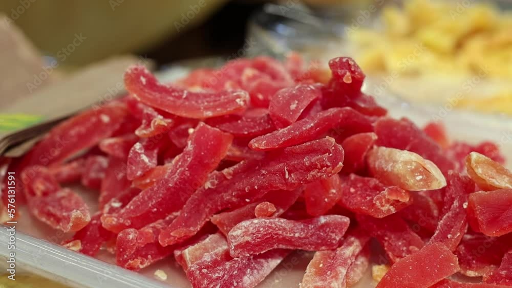 Appetizing dried fruit papaya sticks in a white tray lie on the counter