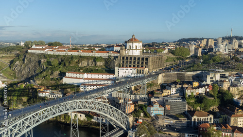 Oporto, Portugal. April 13, 2022: Luis bridge and yellow tram with blue sky.