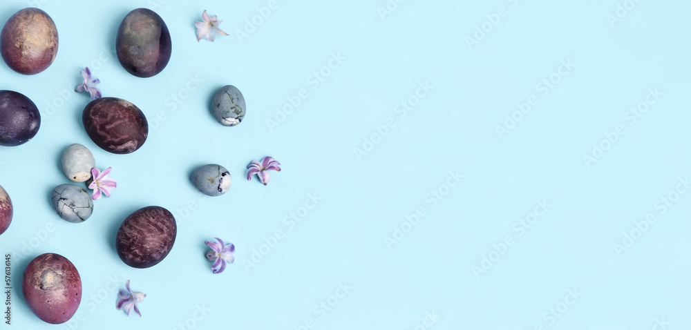 Beautiful painted Easter eggs and hyacinth flowers on light blue background with space for text