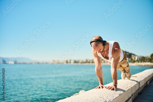 Quadro em tela young guy exercising with calisthenics workout in an outdoor gym