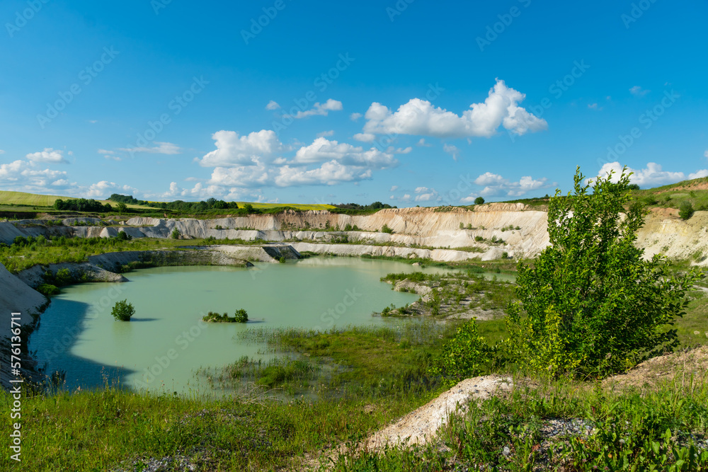 A large sand quarry and a lake. A flooded old abandoned quarry complex. Extraction of sand and stone for industrial applications.