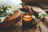 Burning candle and beautiful flowers on wooden table indoors