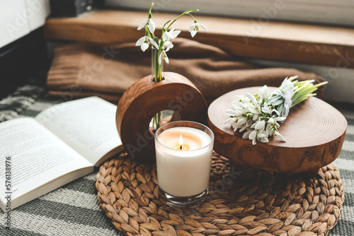 Burning candle and beautiful flowers on wooden table indoors Fototapet