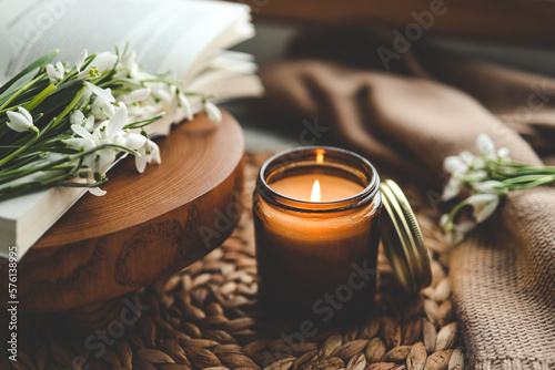Fotografiet Burning candle and beautiful flowers on wooden table indoors