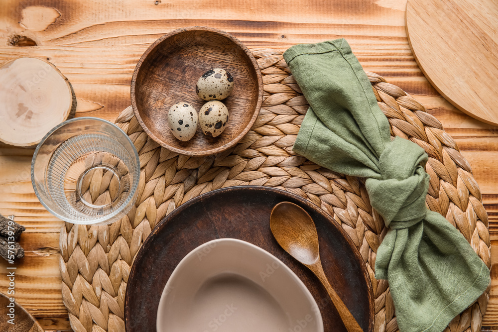 Beautiful table setting with plates, bowl and quail eggs on wooden background Beautiful table setting with plates, bowl and quail eggs on wooden background