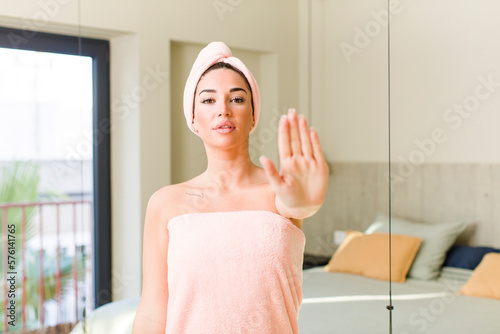 young pretty woman looking serious showing open palm making stop gesture. beauty and shower concept