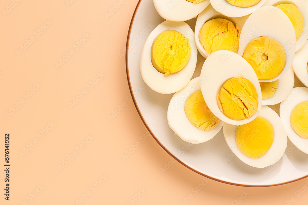 Plate with halves of delicious boiled eggs on beige background Plate with halves of delicious boiled eggs on beige background