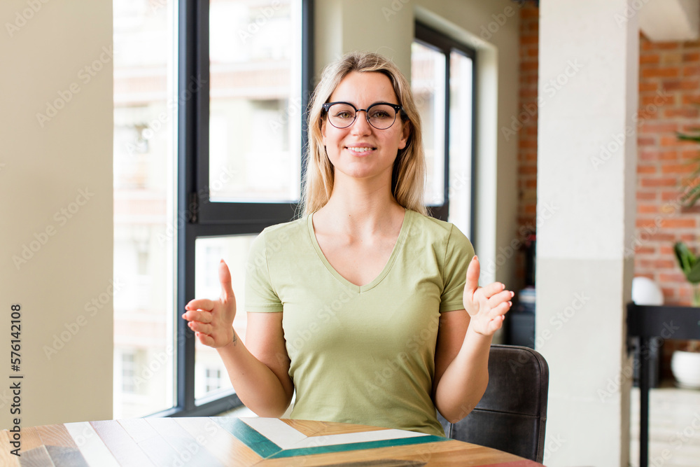 young pretty woman holding an object with both hands on copy space, showing, offering or advertising an object young pretty woman holding an object with both hands on copy space, showing, offering or advertising an object