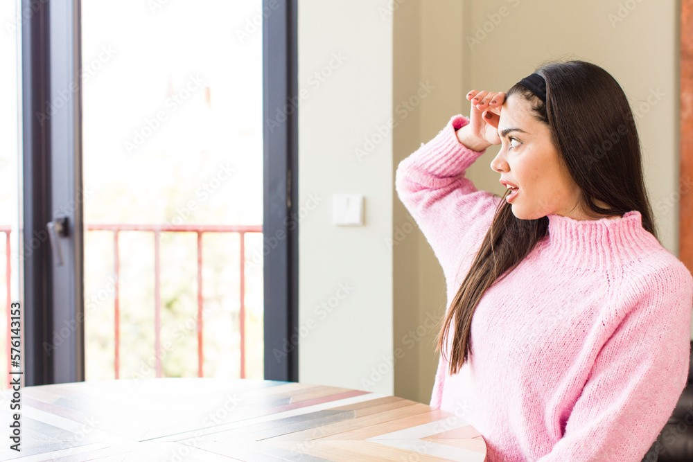 pretty caucasian woman looking bewildered and astonished, with hand over forehead looking far away, watching or searching pretty caucasian woman looking bewildered and astonished, with hand over forehead looking far away, watching or searching