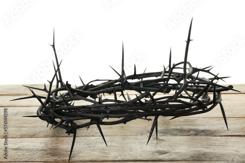Crown of thorns on wooden table against white background