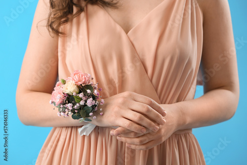 Foto Young woman in prom dress with corsage on blue background, closeup