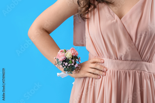 Photo Young woman in prom dress with corsage on blue background, closeup
