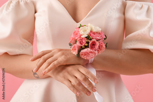 Fotografia Young woman in prom dress with corsage on pink background, closeup