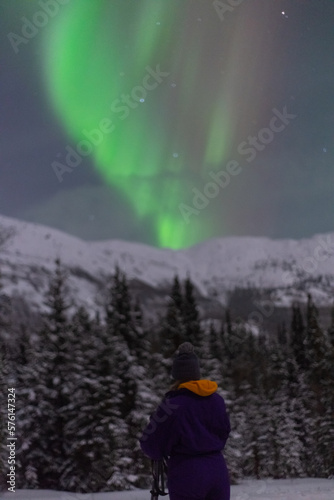 Stunning Aurora Borealis Lights seen in northern Canada during winter time with snow capped mountain in foreground. 