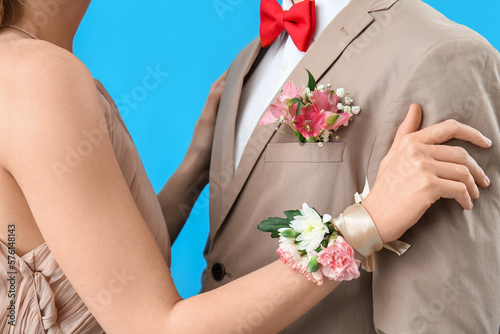 Fotografering Young girl with corsage and her prom date on blue background, closeup