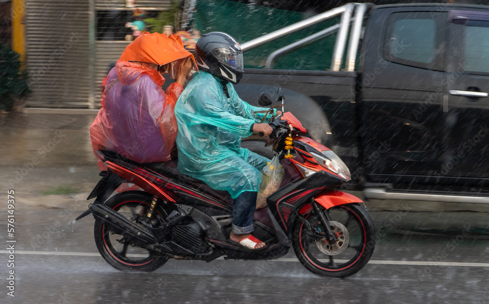 Couple in raincoats drive in rain