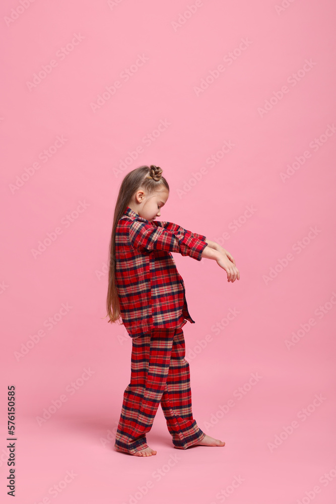 Girl in pajamas sleepwalking on pink background Girl in pajamas sleepwalking on pink background