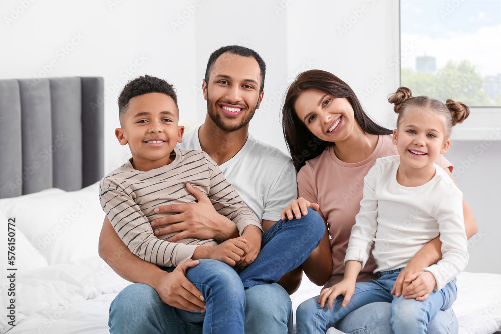 Happy international family spending time together on bed at home Happy international family spending time together on bed at home