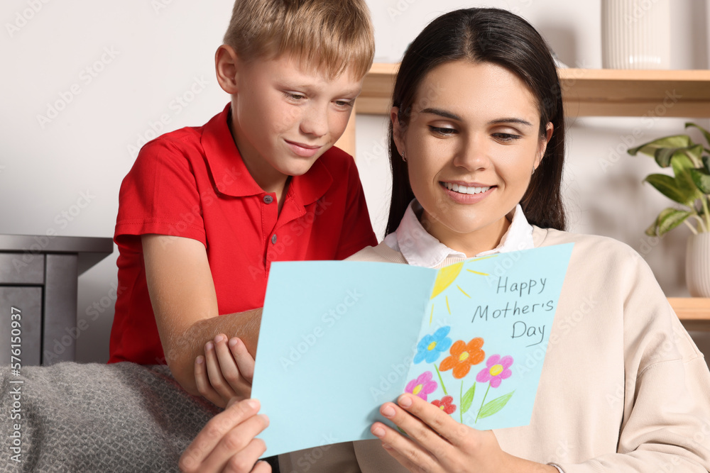 Happy woman receiving greeting card from her son at home Happy woman receiving greeting card from her son at home