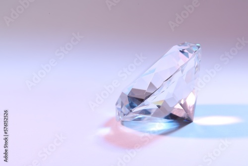 Beautiful dazzling diamond on color background  closeup. Space for text