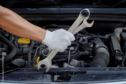 car care maintenance and servicing,hand professional auto mechanic using the wrench to repairing change spare part car engine problem and car insurance service support.