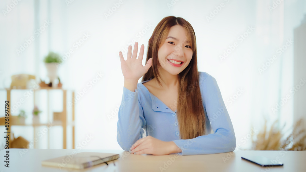 Happy teen asian girl blogger smiling face waving hand talking to webcam recording vlog, social media influencer streaming, making video call at home. Headshot portrait. Webcam view Happy teen asian girl blogger smiling face waving hand talking to webcam recording vlog, social media influencer streaming, making video call at home. Headshot portrait. Webcam view