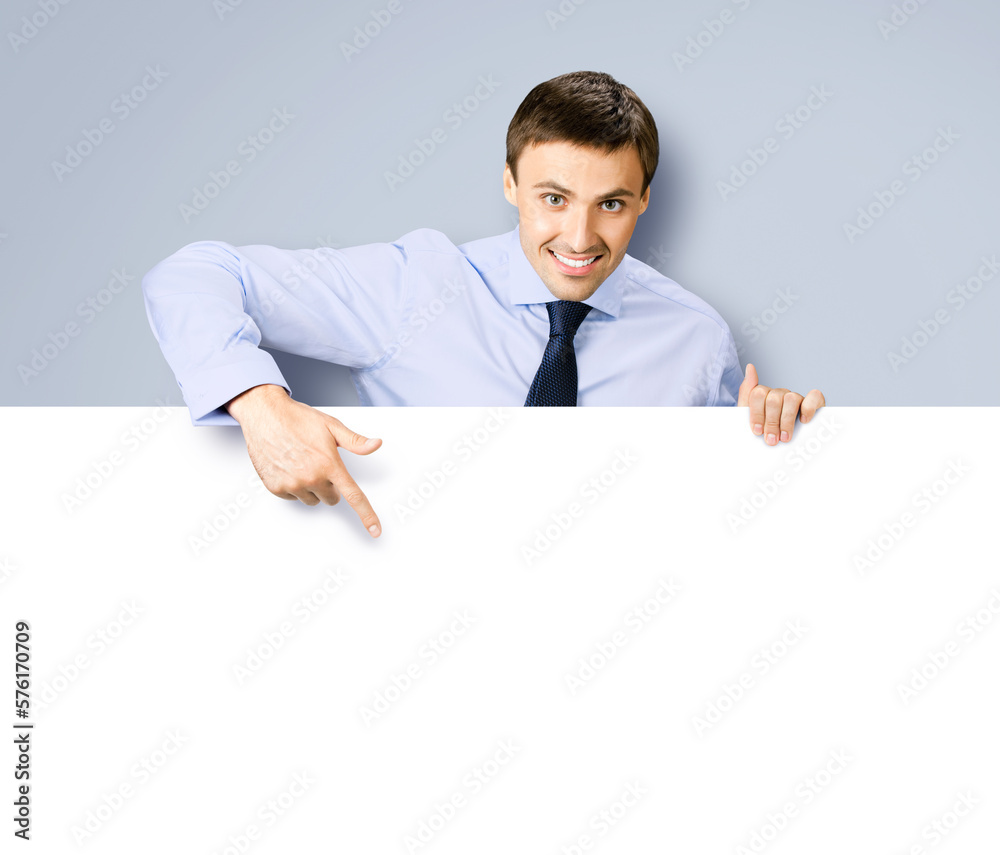 Portrait image of business man professional bank manager in confident cloth. Businessman stand behind, hang over, show point finger empty white banner signboard. Isolated on grey gray background Portrait image of business man professional bank manager in confident cloth. Businessman stand behind, hang over, show point finger empty white banner signboard. Isolated on grey gray background