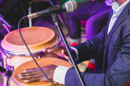 Photography Bongo drummer percussionist performing on a stage with conga drums set kit durin