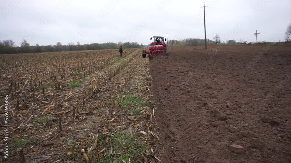 Red tractor plowing the field in Ukraine Red tractor plowing the field in Ukraine